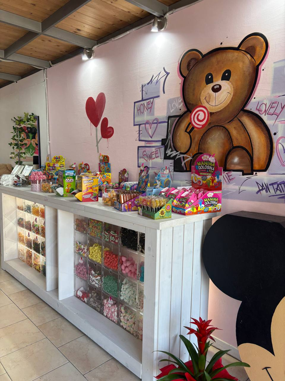 Vista laterale del banco caramelle sfuse e prodotti confezionati di Candy Point